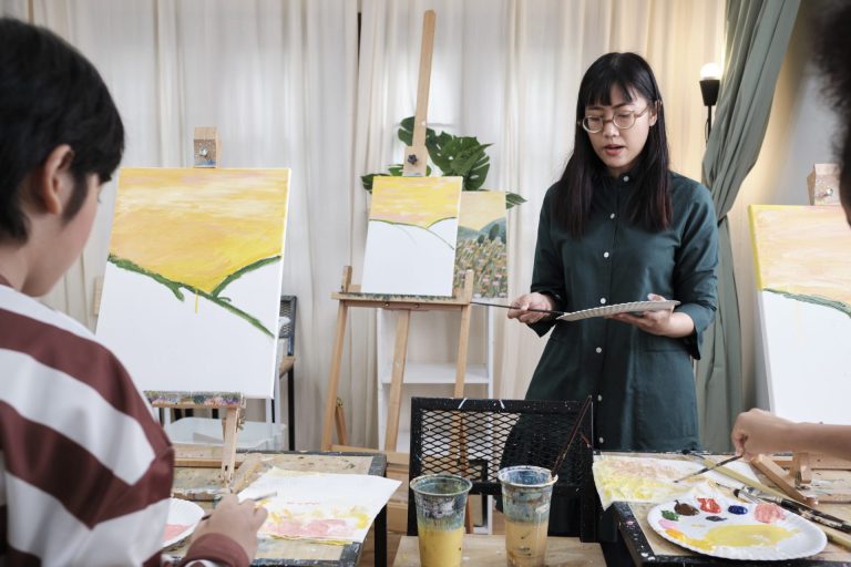 Students paint oil landscapes; canvases at stages